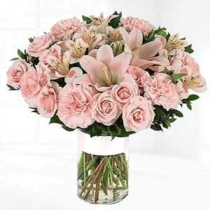 Blossom Stories vase of pink carnation, pink lilies, pink astromeria, greenery with a clear vase.