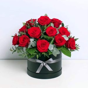 Elegant arrangement of fresh red roses in a black hat box with a satin ribbon, perfect for same-day flower delivery in Nairobi