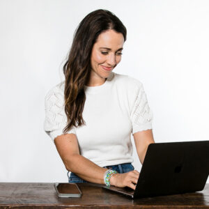 Alison sitting and typing on laptop