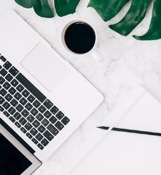 Coffee cup on working desk with laptop