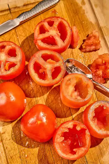 scooping seeds and pulp from tomatoes
