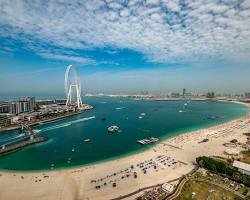 إطلالة ساحرة على أحد شواطئ دبي المجانية مع ظهور برج العرب في الأفق وقت الغروب.