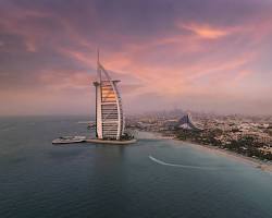 إطلالة ساحرة على أحد شواطئ دبي المجانية مع ظهور برج العرب في الأفق وقت الغروب.