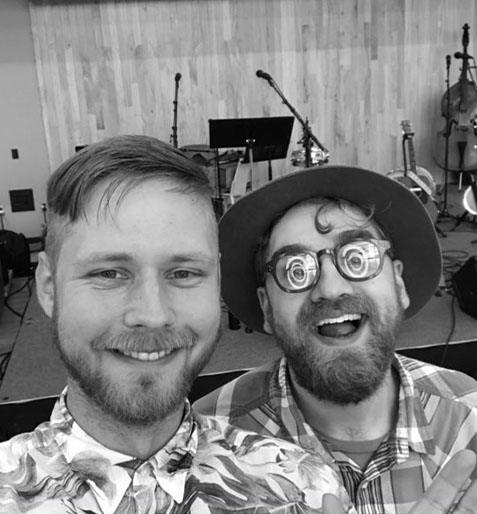 Musicians prepping guitars and double bass on a wood-paneled stage in Grand Rapids Michigan before a live performance.