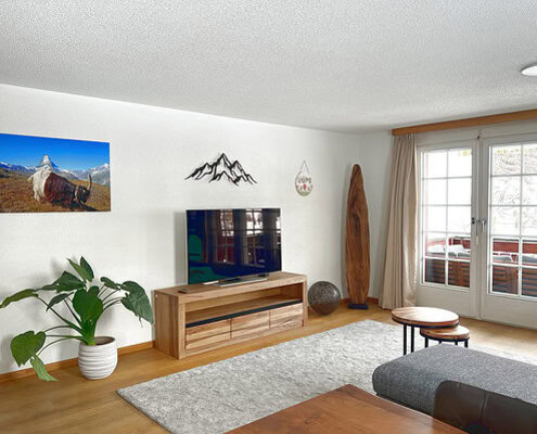 Hütte mit Blick auf Berge und Natur, modernes Ferienapartment in Matterhorn Home, komfortabler Wohnbereich mit Holzdekor, ideal für Winter- und Sommerurlaub in Zermatt.