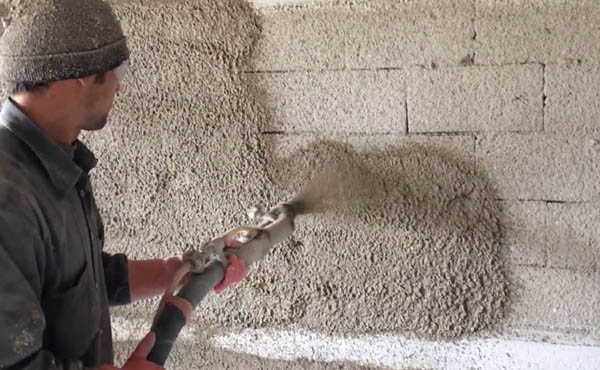 Spray application of Ideal Drymix plaster on block wall