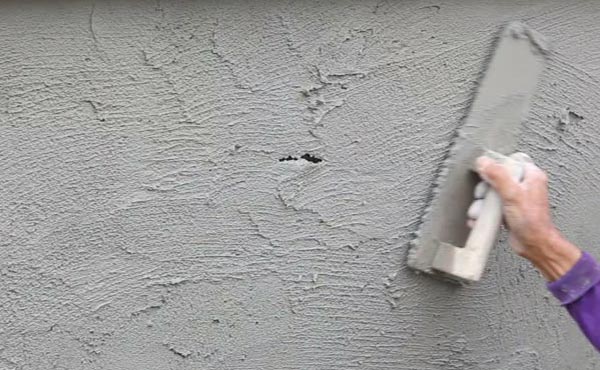 Applying Ideal Drymix plaster for uniform wall finishing