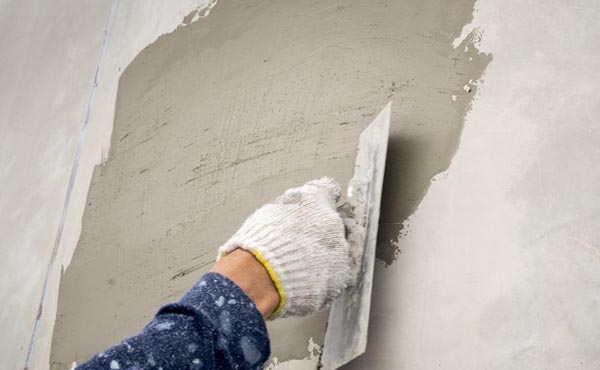 Applying Ideal Drymix ready-mix plaster on interior wall surface