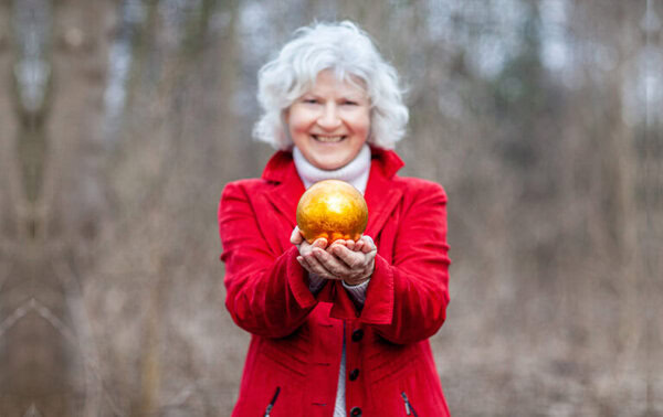 Coaching Angebote: Ein Bild von Katharina mit ihrem Markenzeichen in der Hand - die goldene Kugel