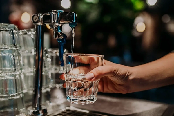 Gewerblicher Getränkebereich mit Zapfhahn und Glas als Beispiel für Wasseraufbereitung im Gewerbe.