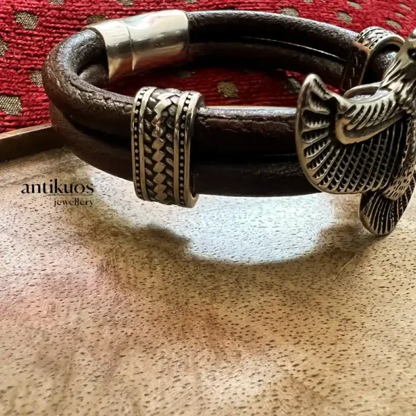 Leather bracelet with silver accents on table.
