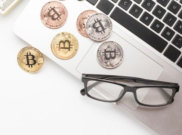 Consulting for cryptocurrency tax complexities: Bitcoin coins on a laptop with glasses