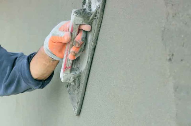 Applying Ideal Drymix plaster with trowel for smooth wall finish
