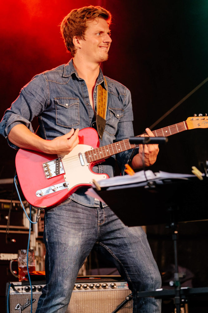 Georg Latz mit Jeansjacke spielt energisch Gitarre