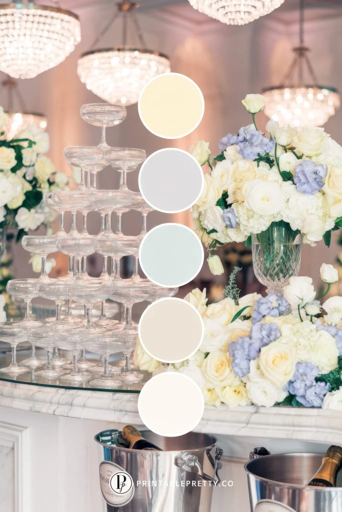 54 Spring Wedding Color Palettes 6 Spring Wedding Color Palette With Cream, Light Gray, Pale Blue, Ivory And White Circles Overlaid On Image Of Elegant Reception With Champagne Tower, White Roses And Blue Hydrangeas Under Crystal Chandeliers