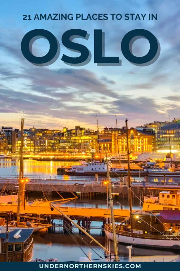 Oslo harbour at sunset with boats and illuminated buildings reflecting on the water.