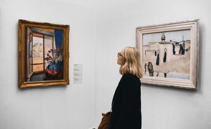 Frau betrachtet zwei Gemälde in einem Museum.