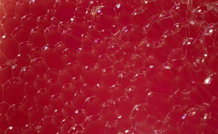 Red soap foam and bubbles close up