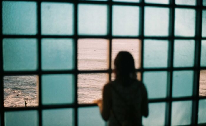 Ein Blick in die psychedelische Zukunft – Person schaut aus dem Fenster auf das Meer.