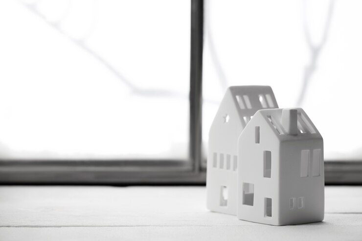 Two white toy house near window