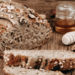 Bananenbrot aufgeschnitten, Honig im Hintergrund