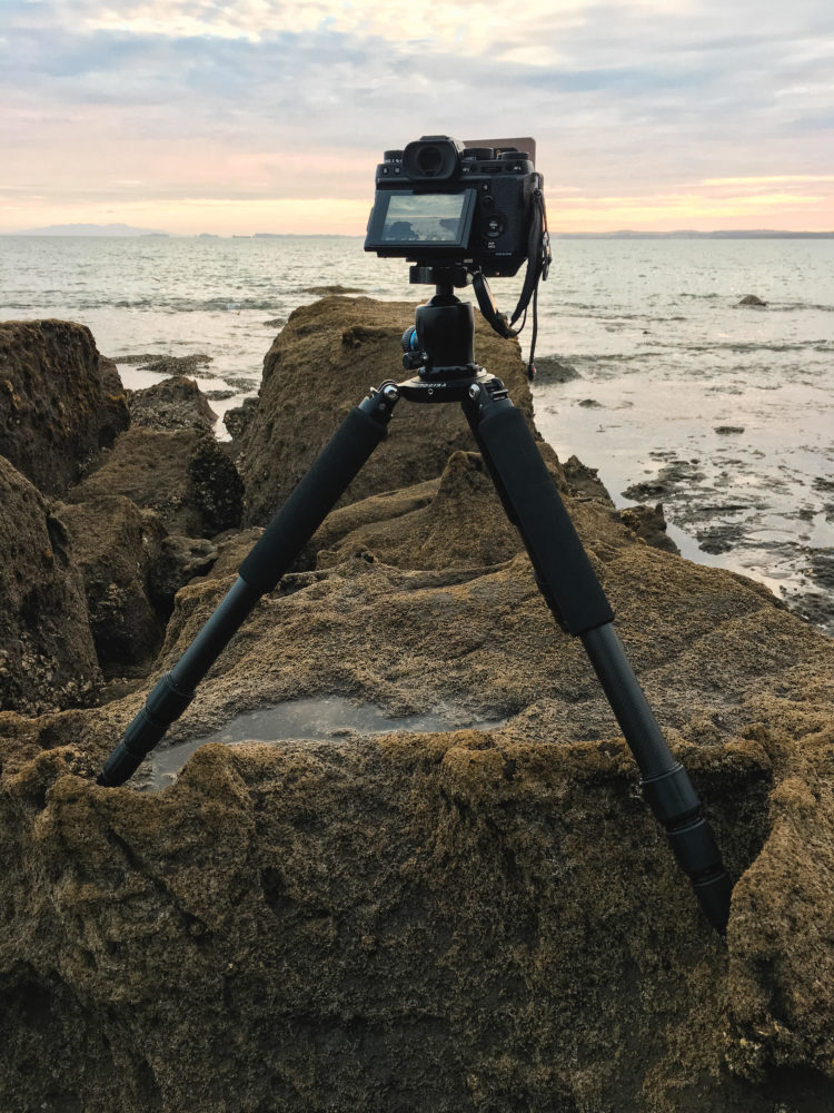 Fujifilm Kamera auf einem Feisol Stativ auf Steinen am Wasser