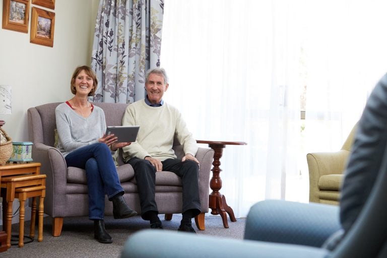 A female support worker looking at an iPad with an elderly gentleman at Mary Chester House respite centre