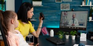 blog image featuring a mother and her young child speaking to a doctor on a computer telemedicine