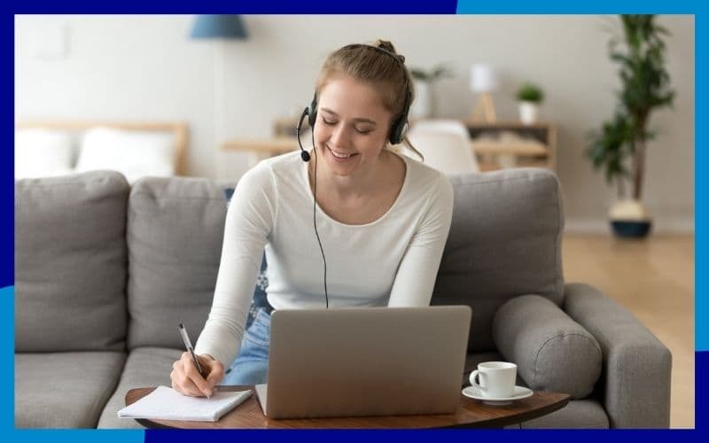 Ragazza con le cuffie seduta sul divano con davanti un pc