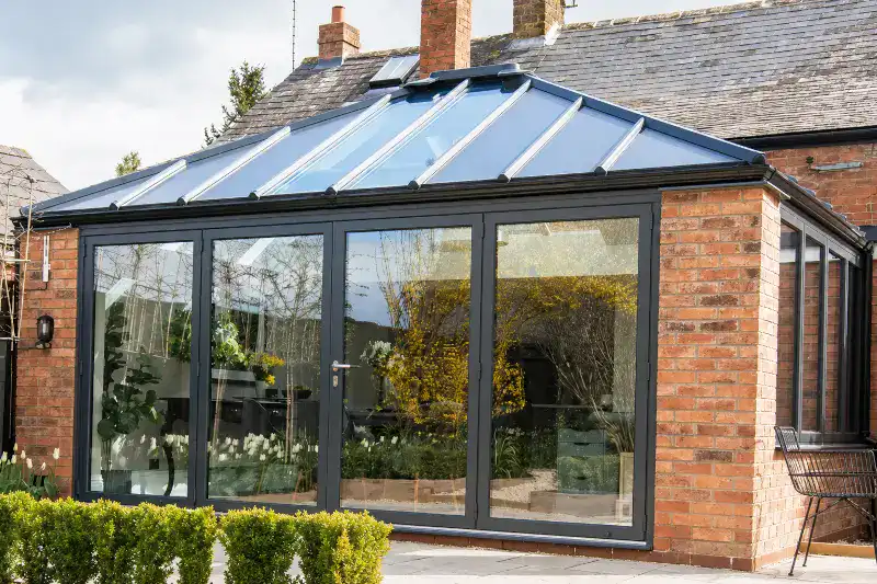 Livinroof conservatory roof replacement on a brick property showing solid insulated panels combined with full-width glazed sections and anthracite grey aluminium frames