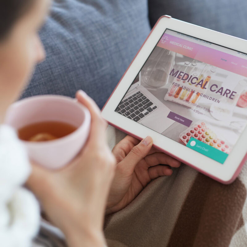 How Brands Can Reach the True Healthcare Decision Maker article banner featuring a woman drinking tea and looking at a tablet with medical care options for her family