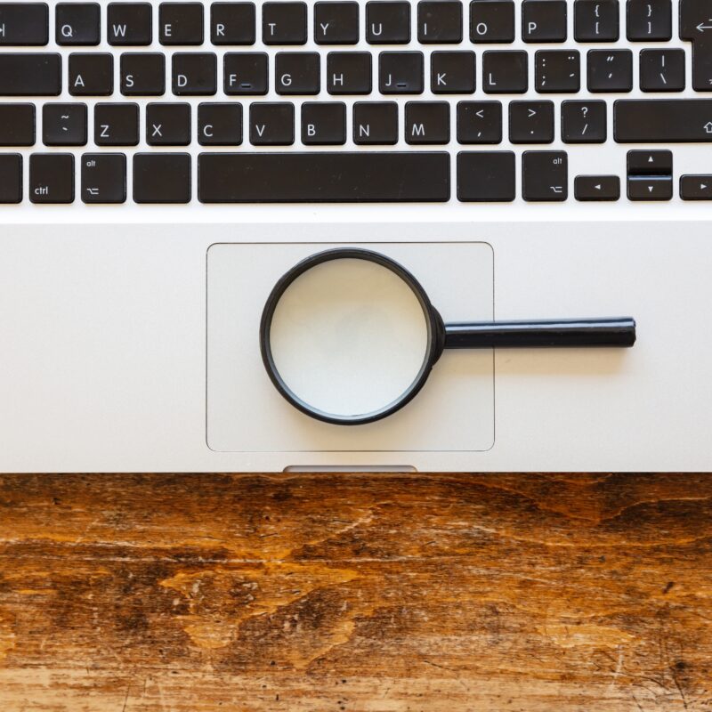 What Is Healthcare E-E-A-T Optimization? article banner featuring a laptop and a magnifying glass