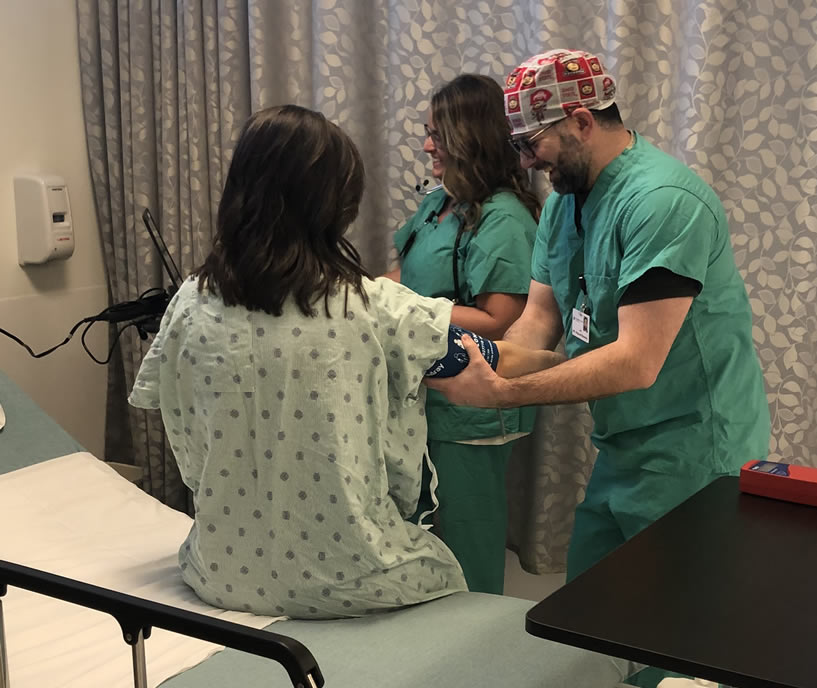 Pre-surgery exam with healthcare team assessing patient vitals. Two medical professionals checking blood pressure of a patient before surgery.