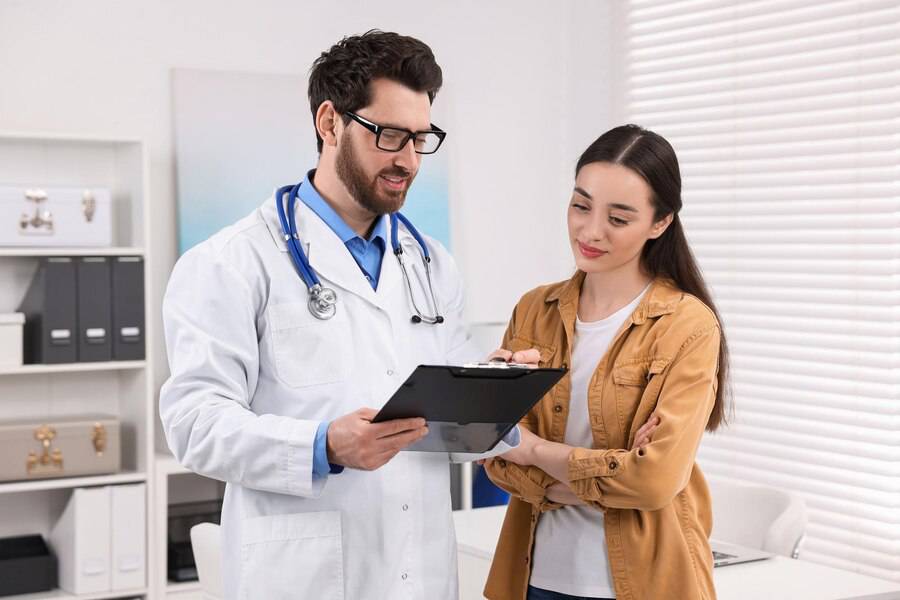 doctor-with-clipboard-consulting-patient-appointment-clinic doctor-with-clipboard-consulting-patient-appointment-clinic