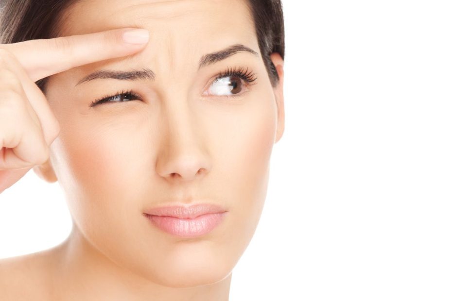 Egy fiatal nő első ráncokkal: szem körüli ráncok, mimikai ráncok.