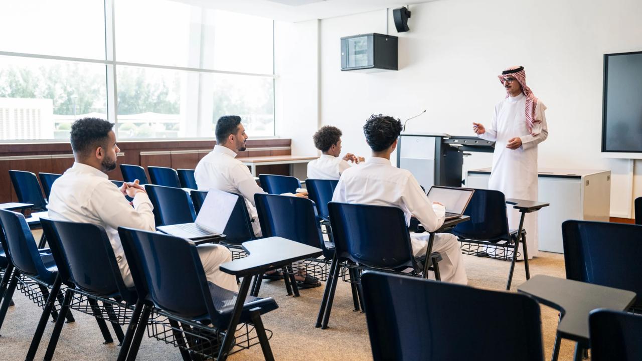 Business consultant presenting to professionals during a corporate training session in Saudi Arabia