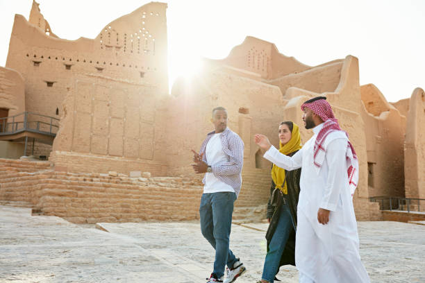 Visitors exploring the historic Diriyah heritage district in Saudi Arabia with a local guide showcasing cultural landmarks