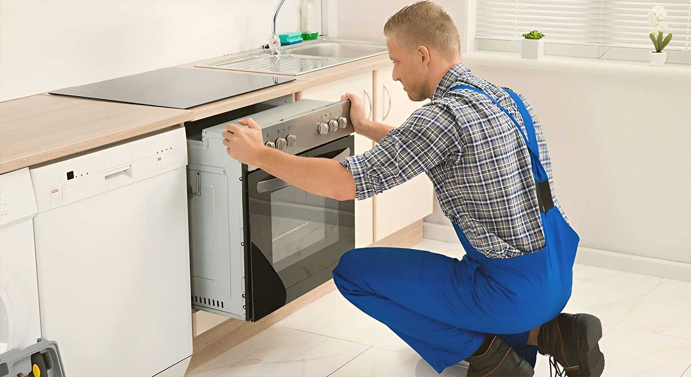 Tecnico durante l'installazione e il fissaggio di un forno da incasso in una cucina nelle Marche da Avanti Arredo