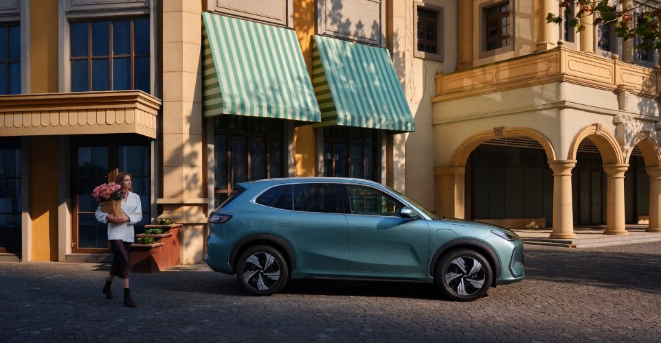 Widok z boku na zaparkowane zielone auto GEELY w środku miasta