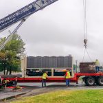 Thumbnail of http://Workers%20unload%20a%20large%20container%20from%20a%20truck%20using%20a%20crane.