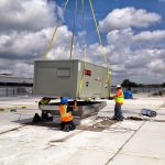 Thumbnail of http://Workers%20installing%20a%20large%20generator%20on%20a%20rooftop.
