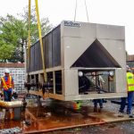 Thumbnail of http://Workers%20installing%20a%20large%20McQuay%20HVAC%20unit%20outdoors.