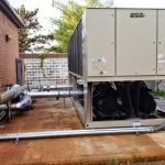 Thumbnail of http://Industrial%20HVAC%20unit%20installed%20outdoors%20on%20a%20concrete%20platform%20beside%20a%20brick%20building.