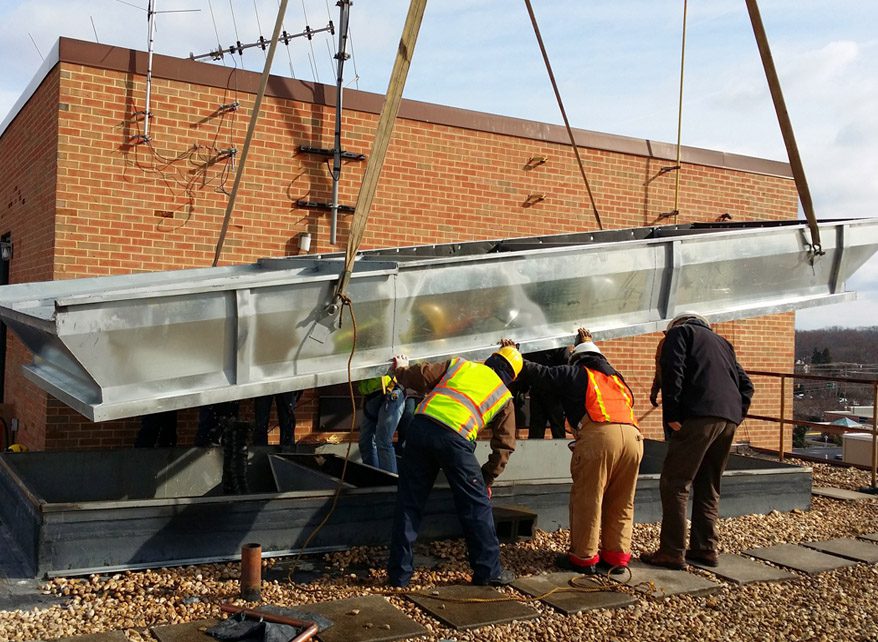 Workers inspecting a metal structure at a construction site.