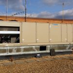 Thumbnail of http://Large%20beige%20industrial%20HVAC%20units%20on%20a%20rooftop%20under%20a%20partly%20cloudy%20sky.