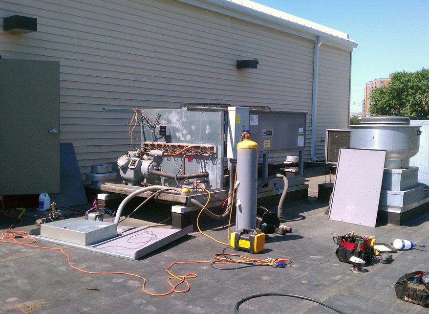 Industrial equipment setup outside a building with gas cylinders and machinery.
