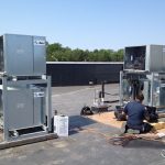 Thumbnail of http://Technicians%20installing%20HVAC%20units%20on%20a%20rooftop%20under%20clear%20skies.
