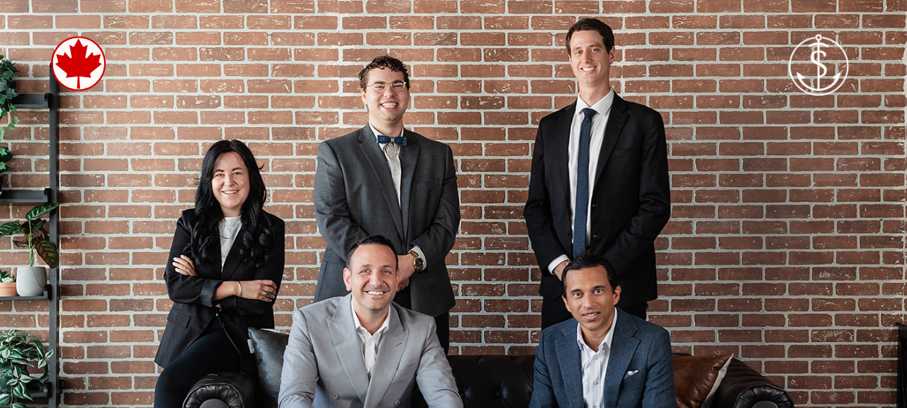 The Safe Pacific Financial team professionally dressed pose in front of a brick wall with plants on the left. Two logos, a red maple leaf and a dollar sign are visible in the top corners. Three are seated on a sofa; two stand behind.