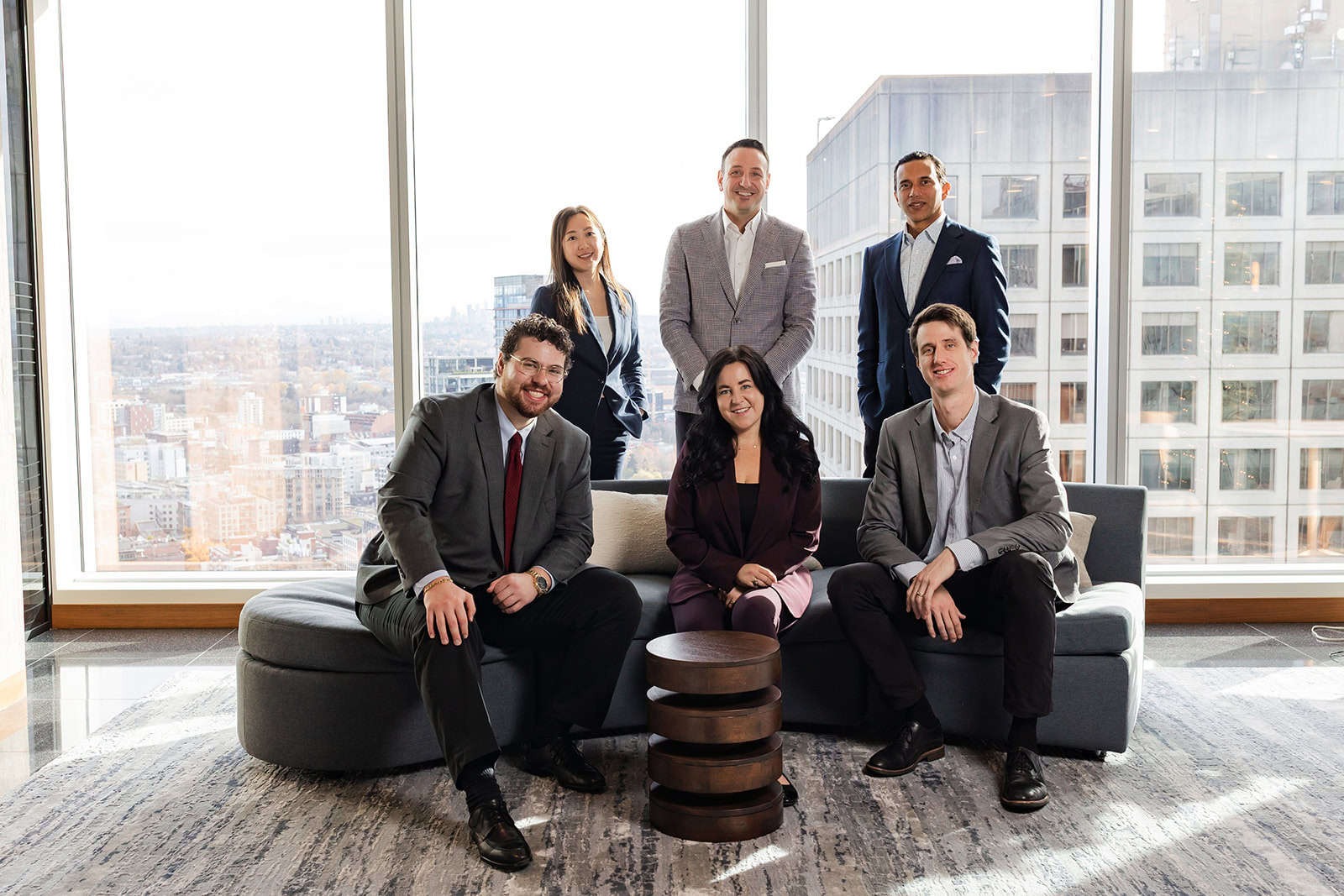 Six Safe Pacific Financial advisors in business attire pose in a modern office, representing bespoke Canadian wealth management and infinite banking for affluent families.