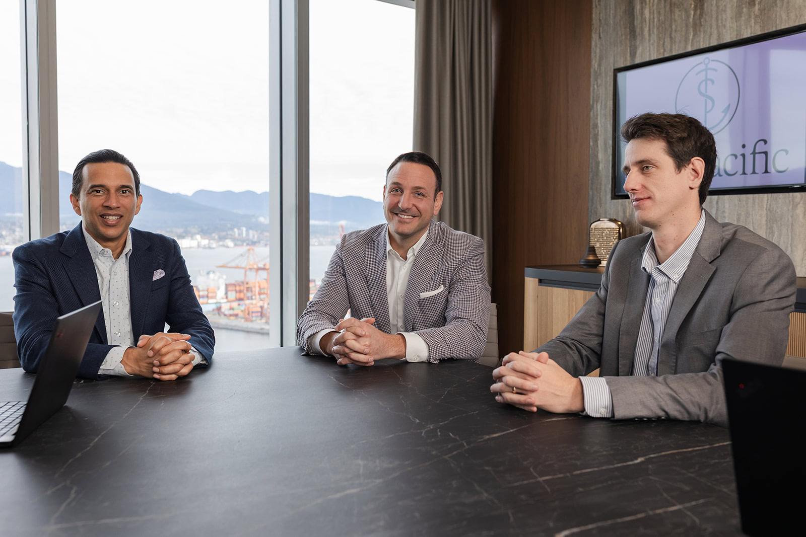Safe Pacific Financial advisors discuss wealth management and infinite banking for affluent Canadian families in a modern boardroom.
